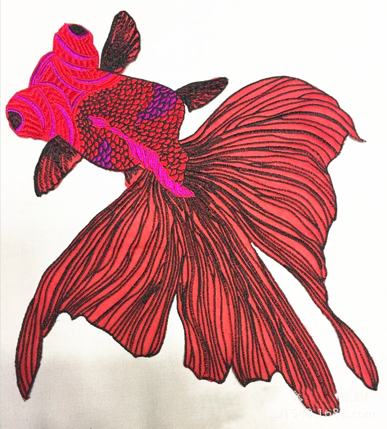 May include: Red embroidered goldfish applique with black outline and pink details. The fish has a large tail fin and is perfect for adding a touch of whimsy to clothing, bags, or home decor.