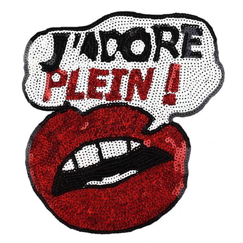 May include: A red sequined patch with a white speech bubble that says "J'adore Plein!" in black lettering.