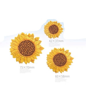 Könnte beinhalten: Drei gestickte Sonnenblumen-Patches in verschiedenen Größen. Der größte Patch ist 75 x 70 mm groß, der mittlere Patch ist 60 x 58 mm groß und der kleinste Patch ist 42 x 37 mm groß.