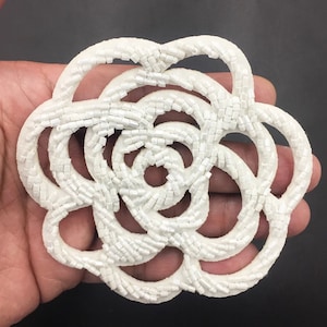 Peut inclure: Applique de fleur blanche en perles avec une forme circulaire et un design délicat et complexe. La fleur est faite de petites perles blanches cousues ensemble pour créer un effet tridimensionnel.