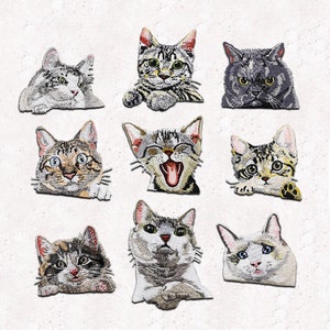 May include: Nine embroidered iron-on patches featuring different cat faces. The patches are in various colors and styles, including gray, white, brown, and black.