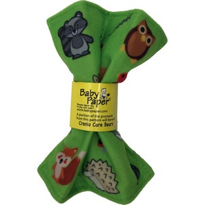May include: A green baby paper product with cartoon animals including a raccoon, owl, fox, and hedgehog. The product is wrapped with a yellow band that has the text "Baby Paper" and website information.