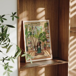 May include: A framed illustration of a person sitting in a room filled with plants. The person is wearing a green shirt and has headphones on. The room has a window with a view of trees and a bookshelf with books and plants. The illustration is titled "Tranquility".
