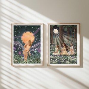 May include: Two framed art prints. One features a woman in a field with a large orange moon and starry sky. The other depicts three women in a forest with a full moon and sunlight. Both prints have a whimsical, ethereal theme.