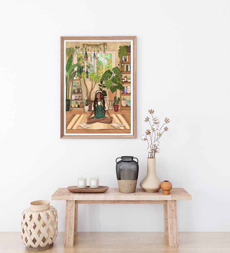 May include: A framed illustration of a woman sitting cross-legged on a rug in a room filled with plants. The woman is wearing a green dress and has headphones on. The room has a window with a view of trees and a bookshelf filled with books.