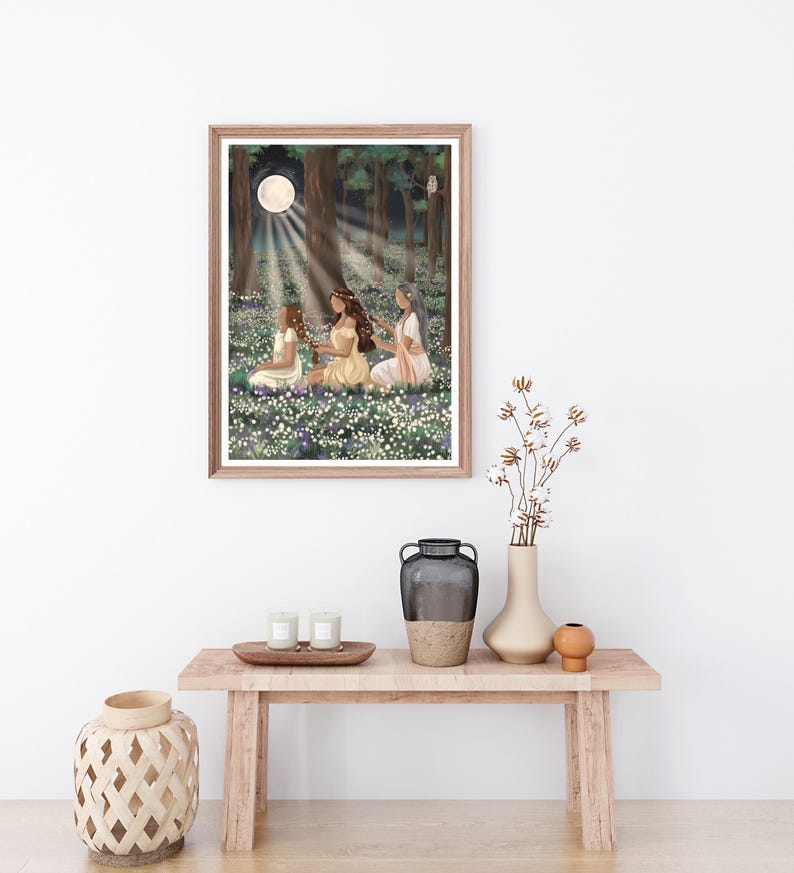 May include: A framed art print depicts three figures in a moonlit forest clearing. The artwork features a full moon, dappled light, and a field of flowers. The figures are seated, wearing flowing dresses, and appear to be in a moment of quiet contemplation.