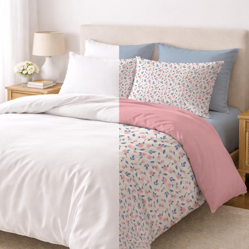 May include: A bed with white, pink, and floral bedding. The duvet cover is white on one side and pink on the other. Two pillows have a floral pattern with pink flowers and blue leaves. The bed also has a light blue sheet and white pillowcases.