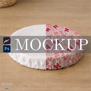 Op de afbeelding: Een ronde mockup in twee tinten met een witte, getextureerde kant en een kant met roze strikken en linten. Het woord "MOCKUP" is wit overgelegd. De afbeelding staat op een houten oppervlak.