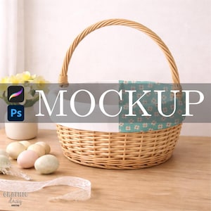 May include: A woven wicker basket with a handle, lined with white fabric and a floral patterned fabric. The word "MOCKUP" is displayed across the basket. Decorative eggs and lace ribbon are on the wooden surface.