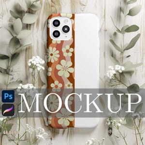 Op de afbeelding: Een witte telefoonhoes met een retro bloemenpatroon in bruin, oranje en crèmetinten. De hoes heeft het woord "MOCKUP" in grote, grijze letters. De telefoonhoes is omgeven door witte bloemen en groene bladeren.