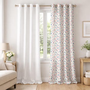 May include: Two window curtains. One is solid white, the other has a cream background with a floral pattern of pink flowers and blue leaves. The curtains are hanging on a gold rod with grommets. The room has a neutral color scheme.