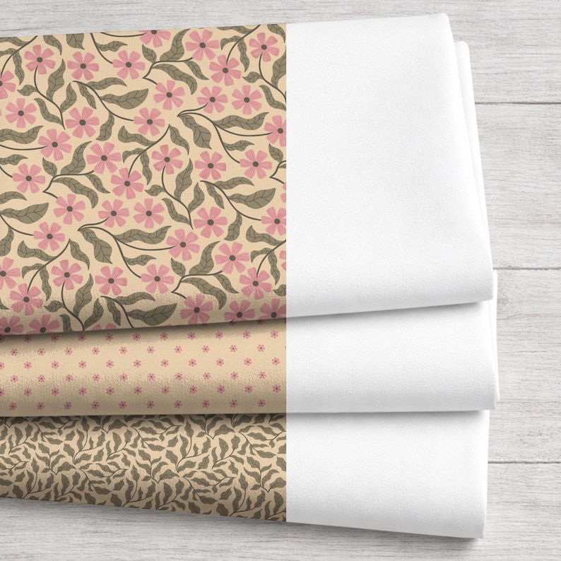 May include: Three fabric swatches with floral and leaf patterns in pink, tan, and brown, alongside folded white fabric. The top swatch features pink flowers and gray leaves on a tan background. The other two swatches have smaller floral and leaf designs.