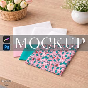 Könnte beinhalten: Ein Mockup mit einem rosa Stoff mit Erdbeer- und Blumenmuster, überlagert mit türkisem und rosa Stoff sowie weißem Stoff. Das Wort „MOCKUP“ ist auf das Bild gelegt. Die Szene spielt sich auf einer Holzoberfläche ab, mit Blumen im Hintergrund.