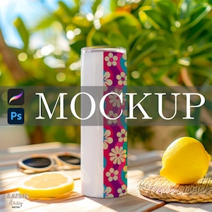 May include: A white tumbler with a colorful floral design and the word "MOCKUP" in large white letters. The floral pattern includes pink, purple, and teal colors. A lemon and sunglasses are in the background.