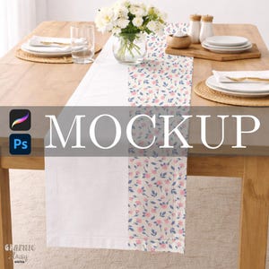 May include: A white table runner with floral patterned panels featuring pink flowers and blue leaves. The runner is set on a wooden table, alongside plates, glasses, and a vase of white flowers. The word "MOCKUP" is displayed across the image.