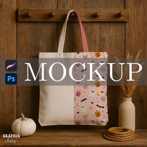 May include: A canvas tote bag with a Halloween-themed pattern. The bag features a light pink background with pumpkins, ghosts, bats, and spiderwebs. The top and one side are plain white, with a pink handle. The word "MOCKUP" is overlaid on the bag.
