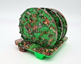 May include: Set of green and gold resin coasters with a metallic finish. The coasters are stacked and have a green base.