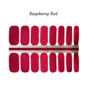 May include: Raspberry Red nail polish wraps, a set of 10 nail wraps on a backing sheet. The nail wraps are a solid red color.