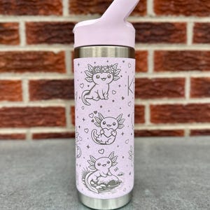 Op de afbeelding: Een lichtpaarse roestvrijstalen waterfles met een herhalend patroon van zwarte lijntekeningen van axolotls, hartjes en kleine sterretjes. De fles heeft een bijpassende lichtpaarse dop met een draagbeugel en een zilverkleurige metalen onderkant.