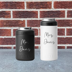 May include: Two insulated beverage holders, one black and one white, with silver tops. The black holder has "Mr. Davis" in script, and the white holder has "Mrs. Davis". Both have the "YETI" logo.