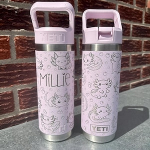 Könnte beinhalten: Zwei hellviolette YETI-Trinkflaschen mit matter Oberfläche, verziert mit einem wiederkehrenden Muster aus schwarzen Axolotl-Strichzeichnungen und Blasen. Eine Flasche ist mit dem Namen Millie in schwarzer Schreibschrift personalisiert. Beide haben einen Tragegriff.