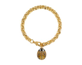 May include: A gold chain bracelet with a small gold ladybug charm. The ladybug has black spots and a black head.