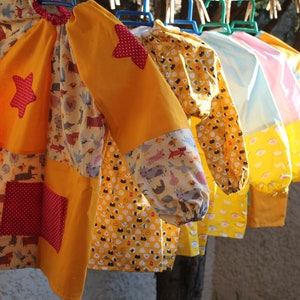 Tablier maternelle taille 3 à 5 ans en coton oeko tex et doublure,fermeture par 2 cordons dans le dos