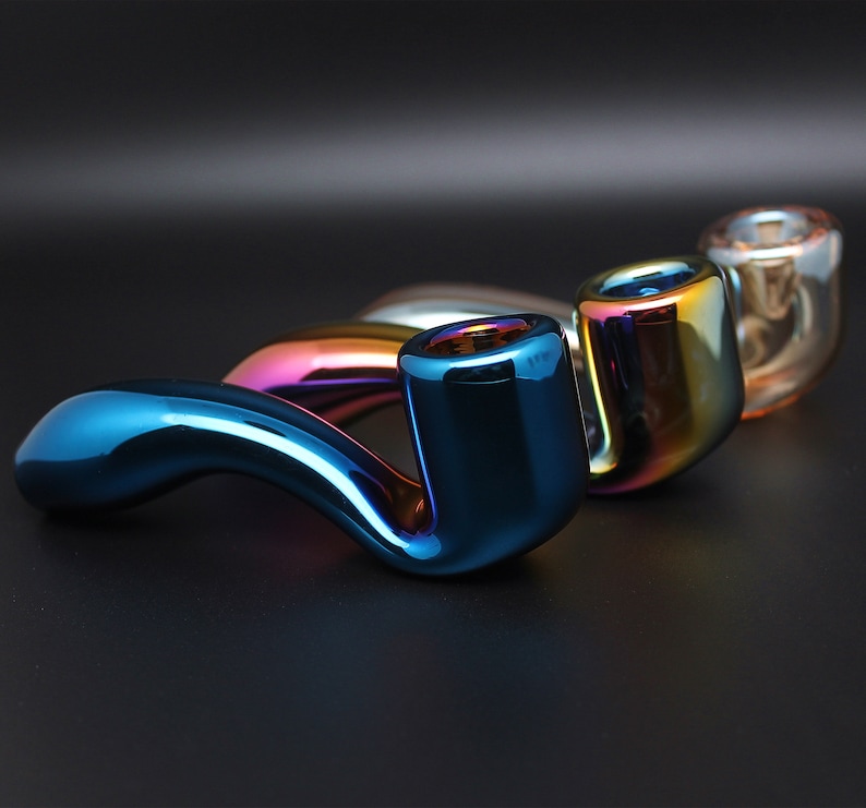 May include: Three iridescent glass smoking pipes, one blue, one green, and one purple, with a curved design.