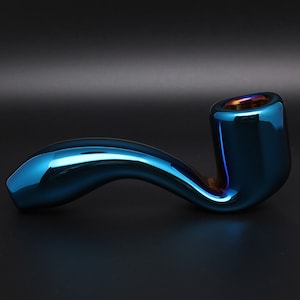 May include: A blue glass pipe with a curved stem and a round bowl. The pipe has a metallic sheen and a slight iridescent effect.