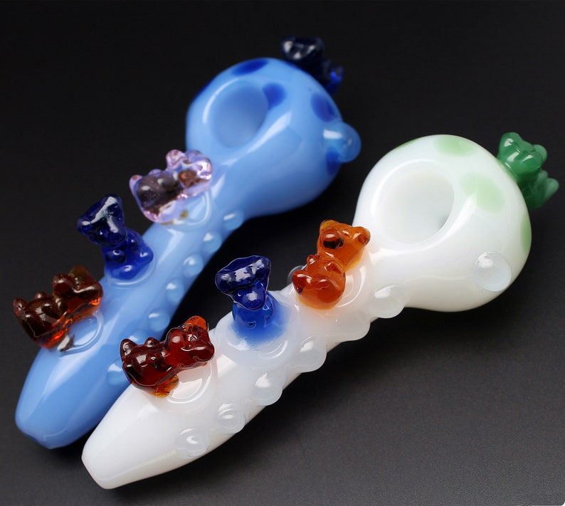 May include: Two glass smoking pipes with colorful bear figurines attached. One pipe is blue with white polka dots and the other is white with green polka dots.