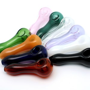 May include: A set of ten glass smoking pipes in various colors, including green, orange, blue, red, white, black, and purple. The pipes are arranged in a fan shape on a white background.