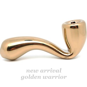 May include: A gold-colored pipe with a smooth, curved design. The pipe is made of metal and has a shiny finish.