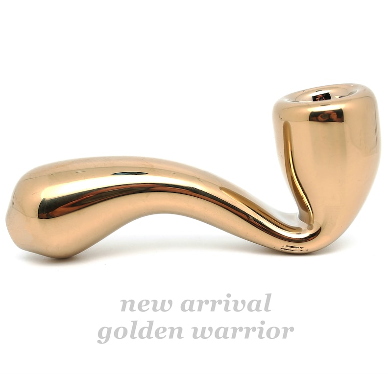 May include: A gold-colored pipe with a smooth, curved design. The pipe is made of metal and has a shiny finish.