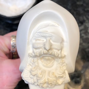 Può includere: Figurina in ceramica bianca di un uomo con la barba e una benda sull'occhio. La figurina è dettagliata con una barba testurizzata e un viso scolpito.