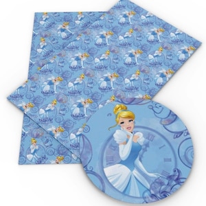 May include: Blue and purple fabric with a repeating pattern of Cinderella in a blue dress and a glass slipper. The fabric also features a clock and a carriage.