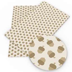 May include: A sheet of white faux leather with a brown acorn pattern. The acorns are repeated in a regular pattern across the entire sheet.