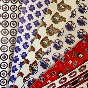 Peut inclure: Six bandes de tissu sur le thème du hockey de différentes équipes. Les bandes sont blanches avec différents logos et couleurs d'équipe. Les logos incluent les Maple Leafs de Toronto, les Oilers d'Edmonton, les Flames de Calgary et les Canadiens de Montréal.