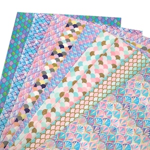 May include: A set of eight different mermaid scale patterned faux leather sheets in various shades of blue, pink, and green with gold glitter accents.