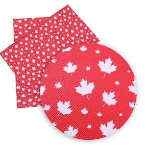 May include: Two sheets of red fabric with white maple leaf patterns. One sheet has small maple leaves, the other has larger maple leaves.