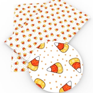 May include: White background with a repeating pattern of orange and yellow candy corn with small white dots.