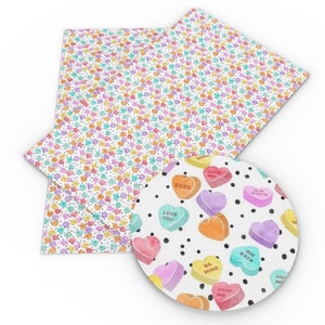 May include: White fabric with a repeating pattern of colorful candy hearts with different messages. The fabric is shown with a close-up of a single candy heart with the message "Love You" on it.
