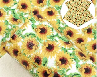 May include: White faux leather sheet with a repeating pattern of yellow sunflowers with brown centers and green leaves.