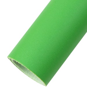 Peut inclure: Un rouleau de tissu en simili cuir vert vif. Le tissu a une surface texturée.