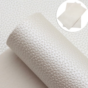 Peut inclure: Gros plan sur une feuille de simili cuir blanc avec une surface texturée et caillouteuse.
