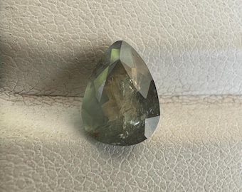 May include: A pear-shaped green gemstone with a faceted cut. The stone has a translucent appearance with a slight shimmer.