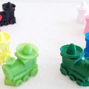 May include: Ten colorful toy train engines with sombrero hats. The trains are in various colors, including red, orange, yellow, green, blue, purple, pink, and black.