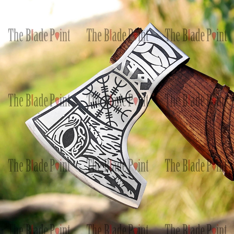 May include: Axe with a polished silver head and a wooden handle. The axe head features etched designs, including a compass-like symbol and other intricate patterns. The handle is a dark brown color. The text "The Blade Point" is repeated around the image.