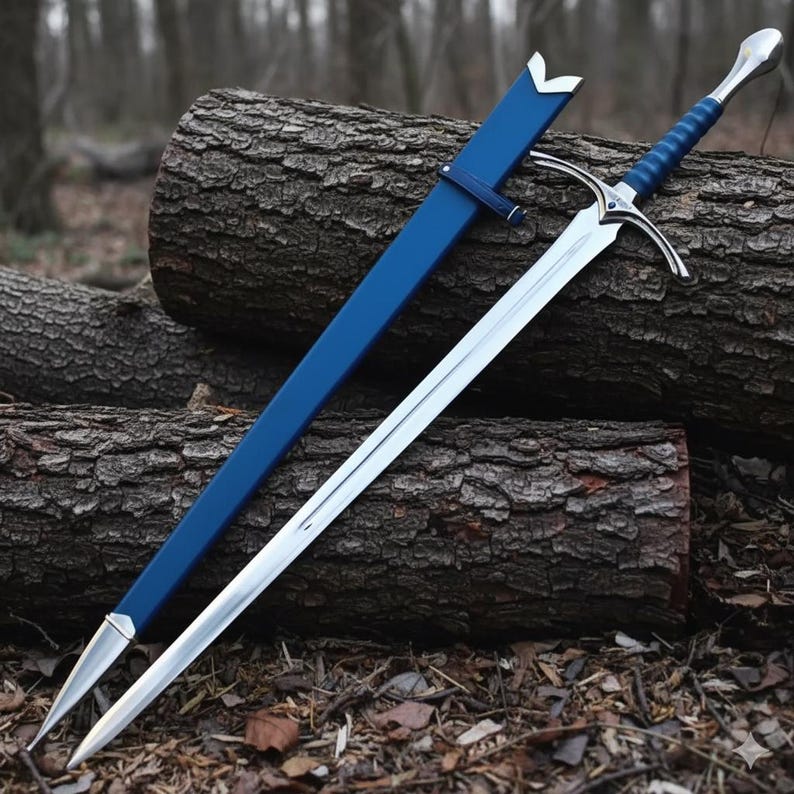 May include: A silver-toned metal sword with a blue-wrapped handle and a matching blue scabbard. The sword features a pointed blade, a crossguard with a small blue accent, and a rounded pommel. The scabbard has silver metal fittings.