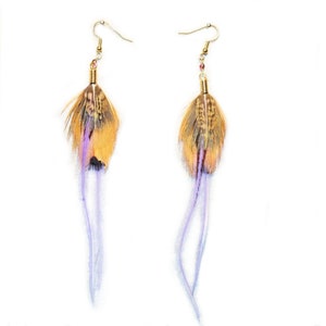 May include: A pair of long feather earrings with a gold hook and a purple feather accent. The feathers are brown, yellow, and orange.