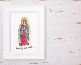 May include: A framed watercolor illustration of Our Lady of Guadalupe featuring a figure in a red dress and blue mantle with gold rays, standing above red and purple flowers. The text Our Lady of Guadalupe is written in black script below.